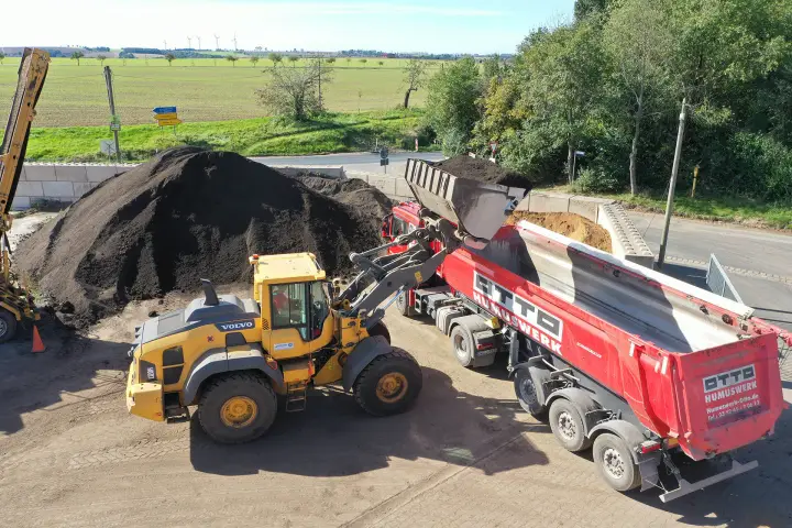 LKW wird von Bagger mit Schüttgut beladen